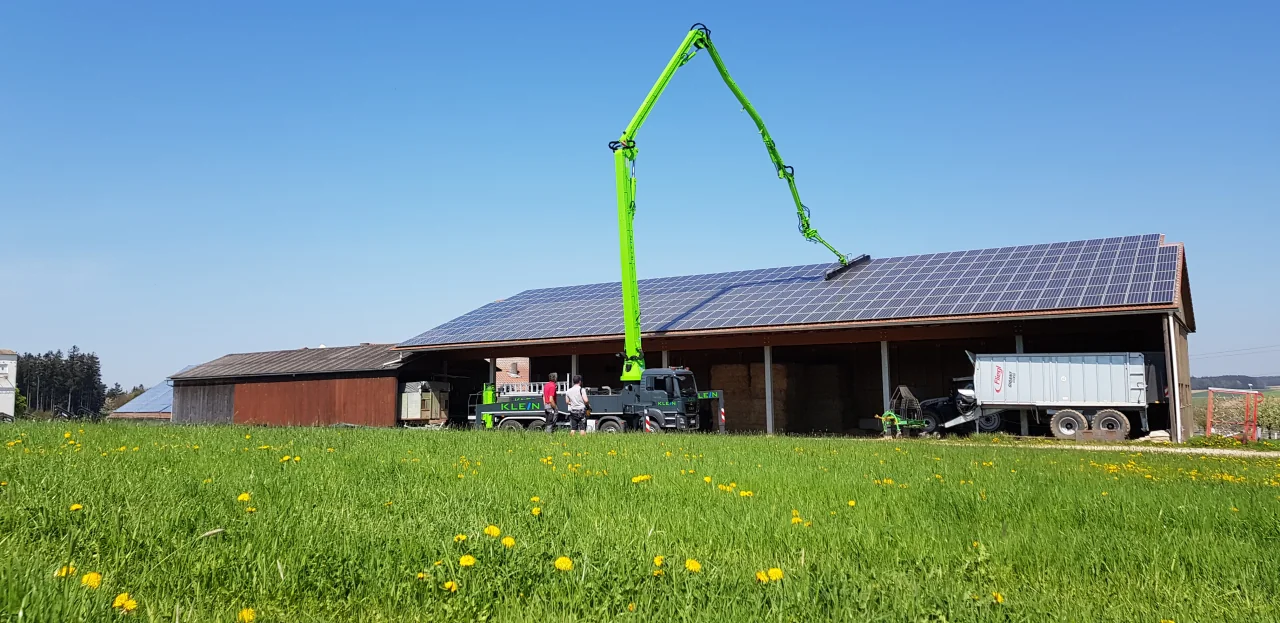 KLEIN Spezialfahrzeug mit ausgefahrenem Ausleger vor einer landwirtschaftlichen PV-Dachanlage